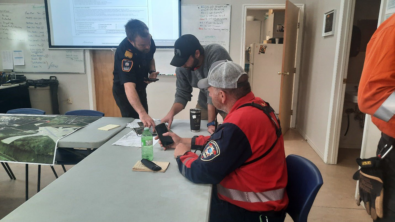 Emergency responders reviewing maps and phones indoors