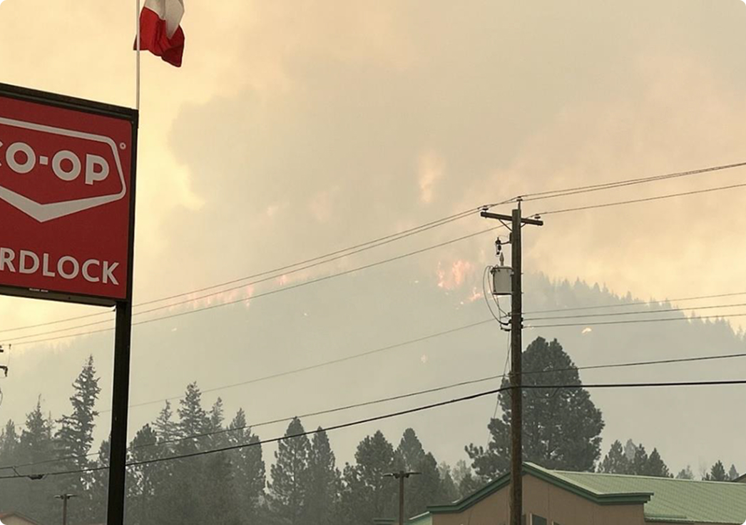 Wildfire burning on hillside behind town buildings